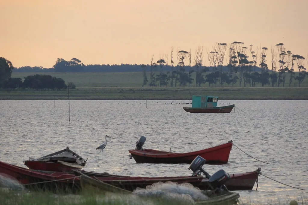 Small fishing boats beside Laguna de Rocha at sunset