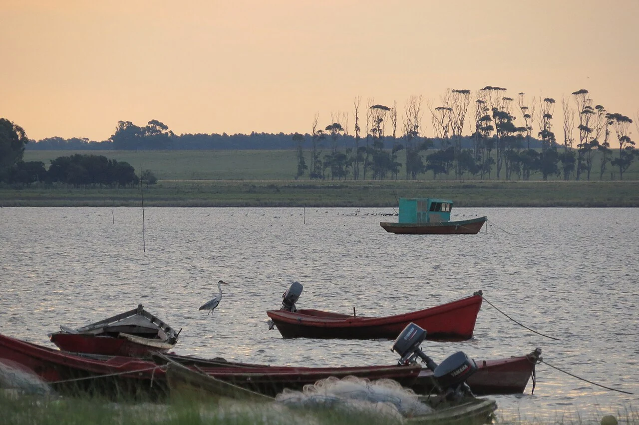 Small fishing boats beside Laguna de Rocha at sunset
