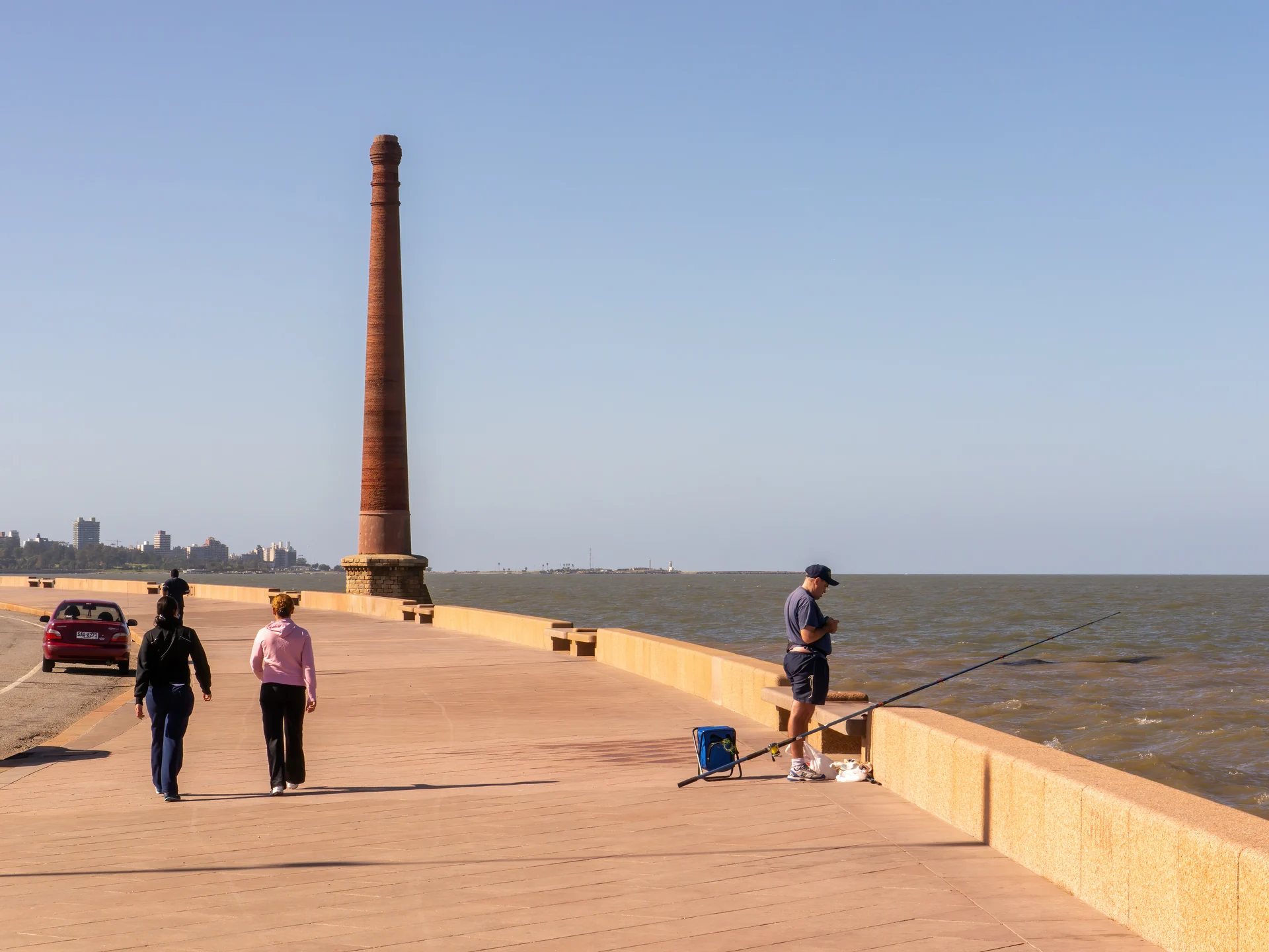 People walking beside the Río de la Plata on Montevideo’s southern Rambla